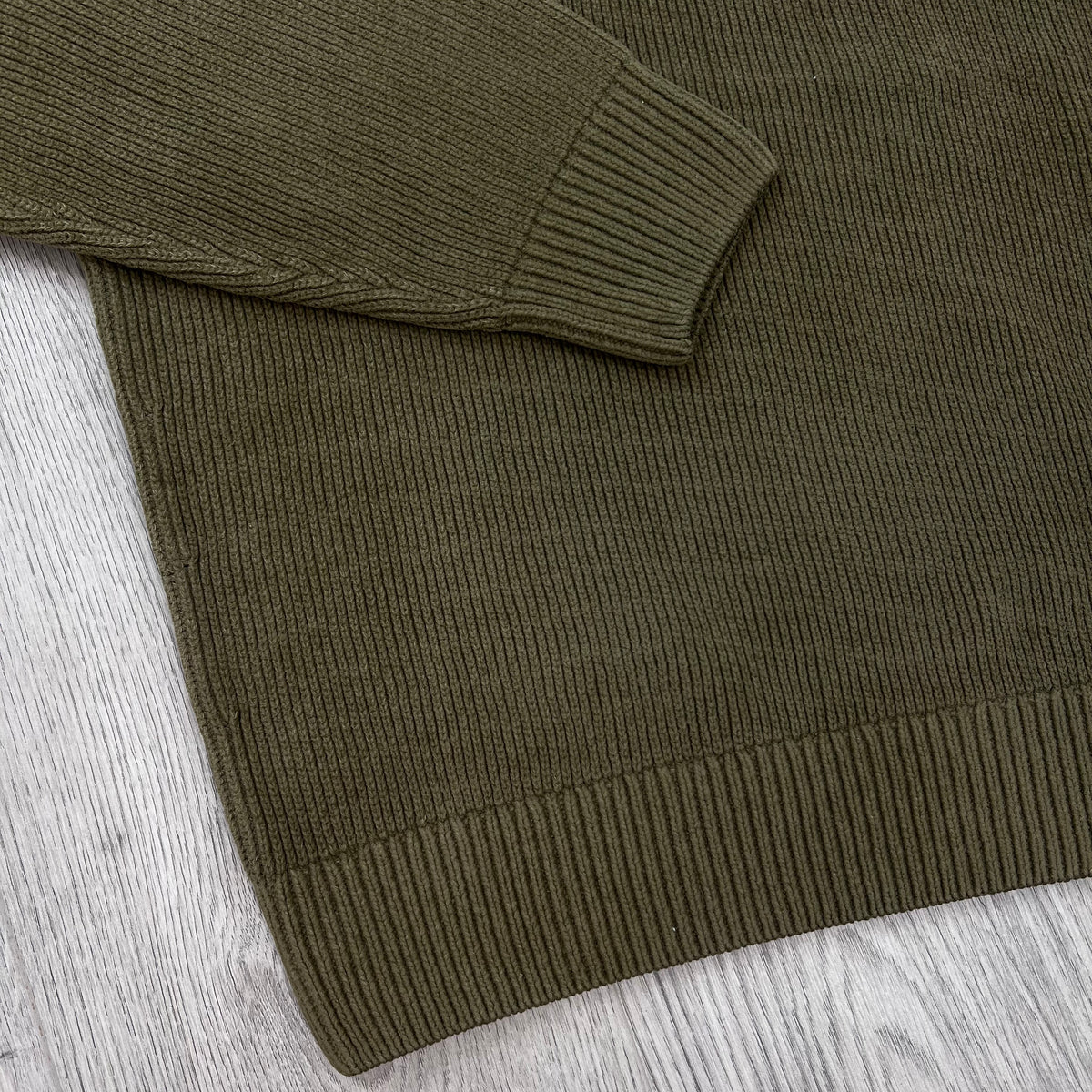 Close up view of the ribbed cuffs and hem on a CP Company Chenille Knit Polo Sweatshirt in Ermine.