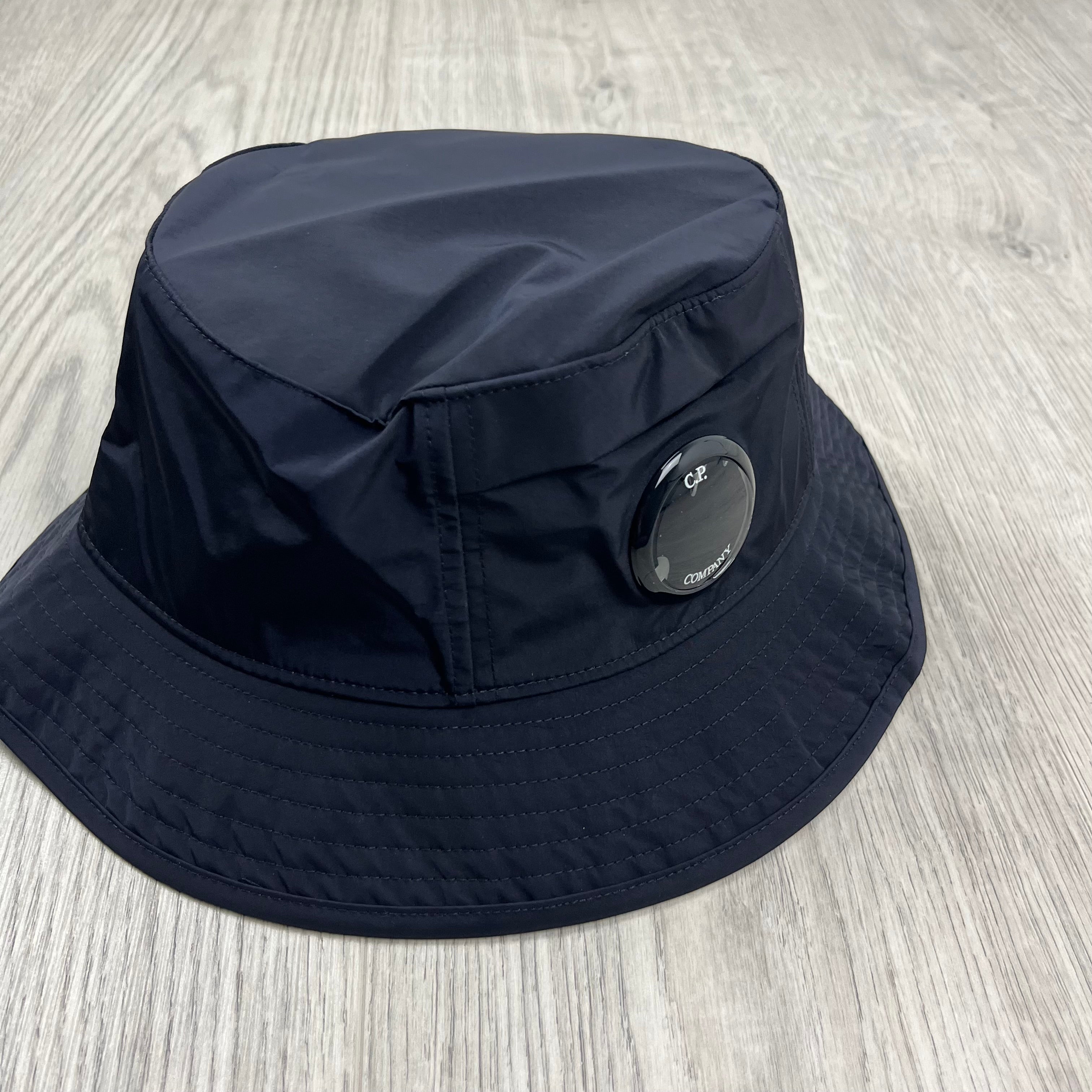 CP Company Lens Bucket Hat in Total Eclipse Navy Blue. On sale at Open Attire.