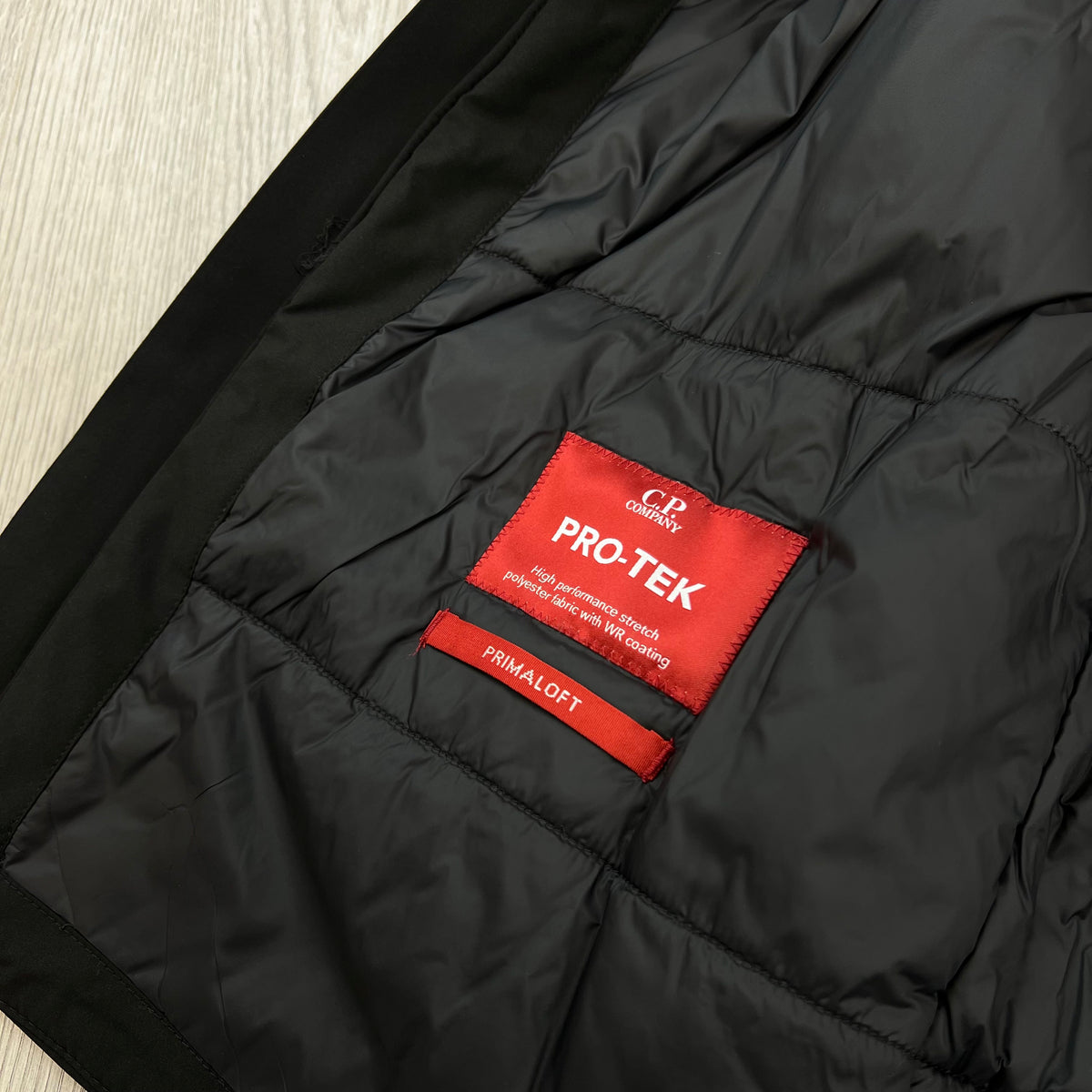 Product material label on the inside of a CP Company Pro-Tek PrimaLoft Gilet in Black.