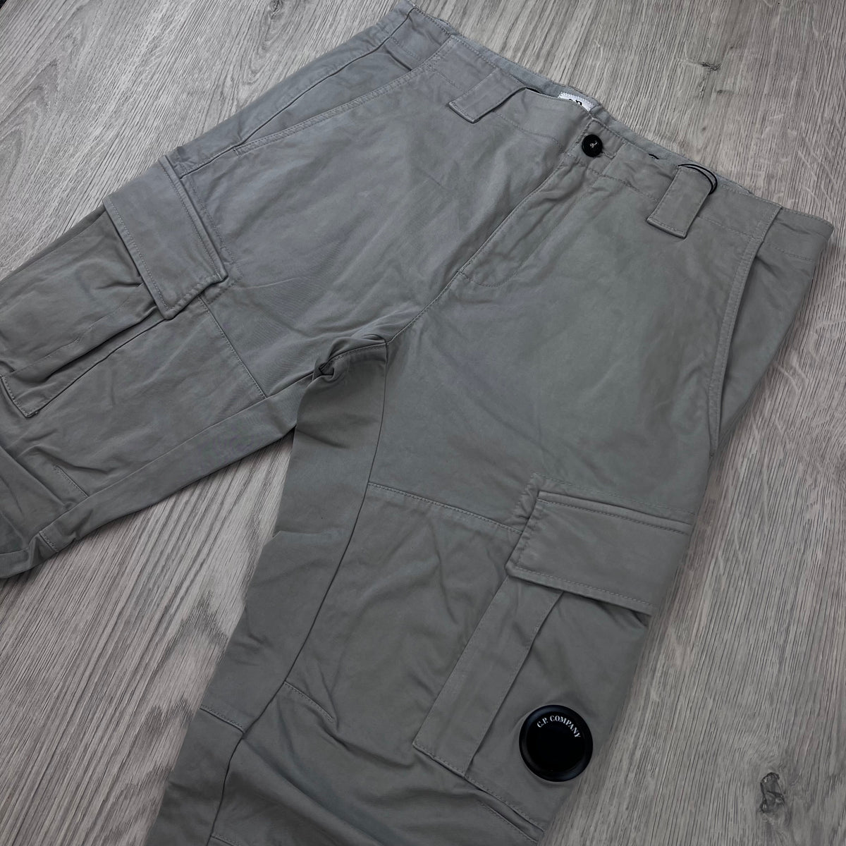 Angled view of the CP Company Stretch Sateen Cargo Trousers in Flint Grey.