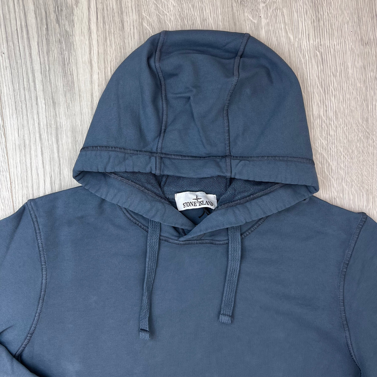 A close up view of the hood and drawstring on a Stone Island Pullover Hoodie in Slate Blue.