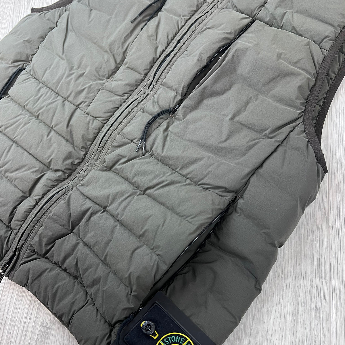 Angled view of the quilted down padding on a Stone Island Seamless Tunnel Nylon Down-TC Down Gilet in Coal Grey. 