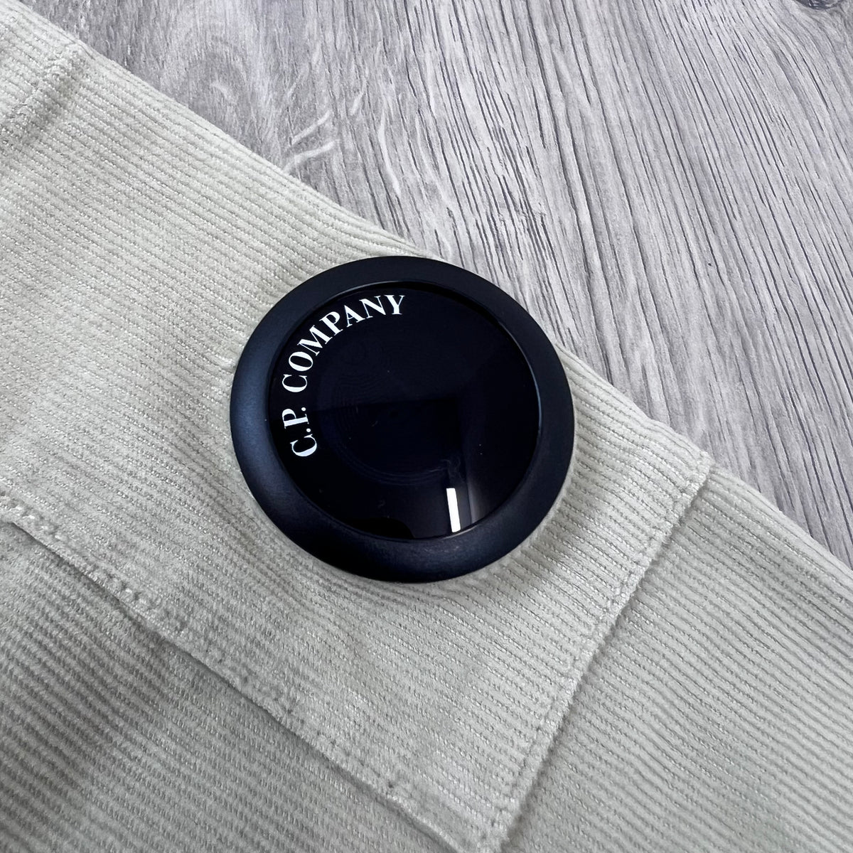 Close up view of the NFC sleeve lens detail on a CP Company Cotton Corduroy Overshirt in Silver Birch.