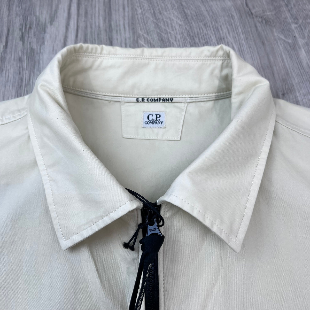 Close up view of the polo collar and neck label on the CP Company Zip Overshirt in Silver Birch.