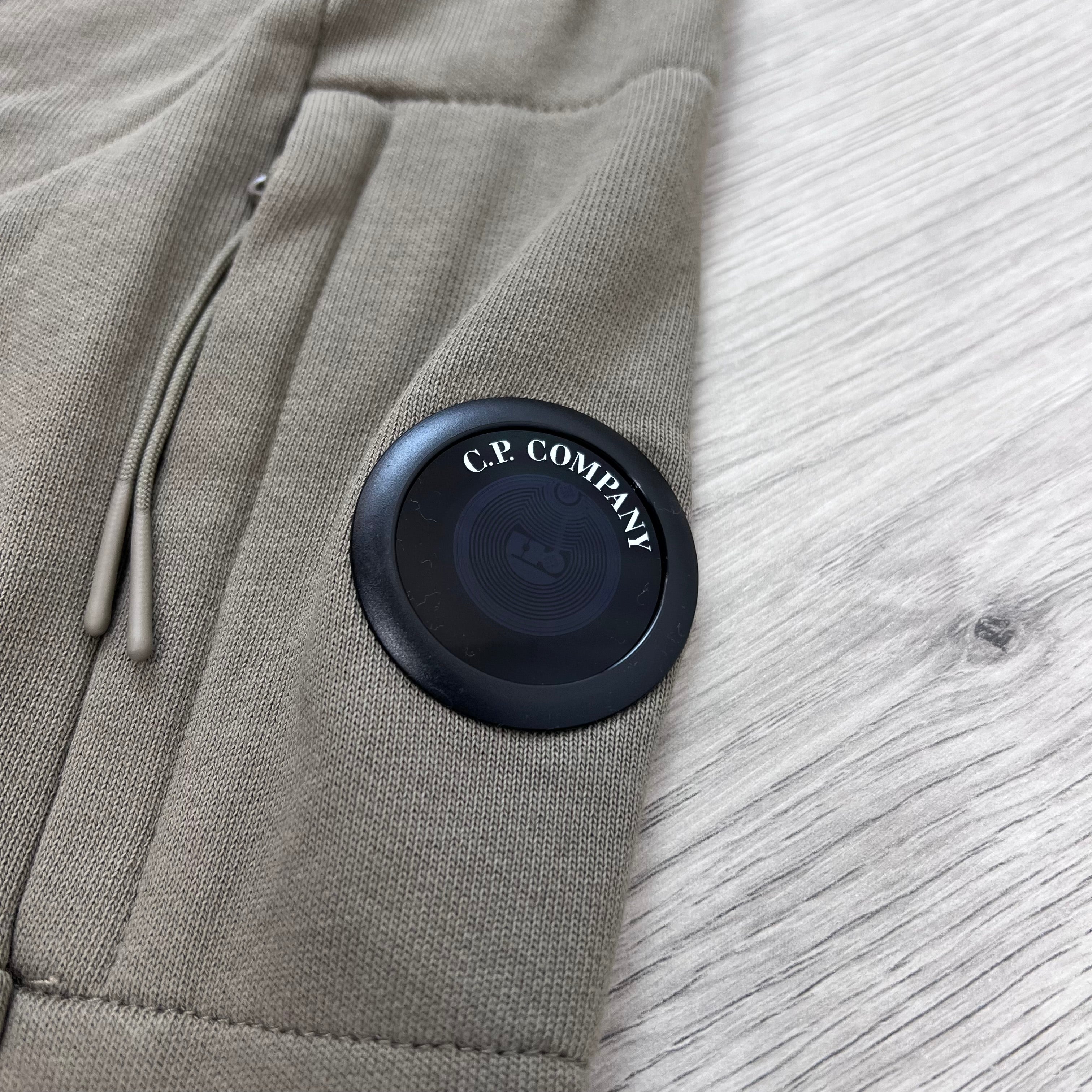 A close up view of the Lens detail on a CP Company Raised Fleece Zip Hoodie in Fallen Rock.
