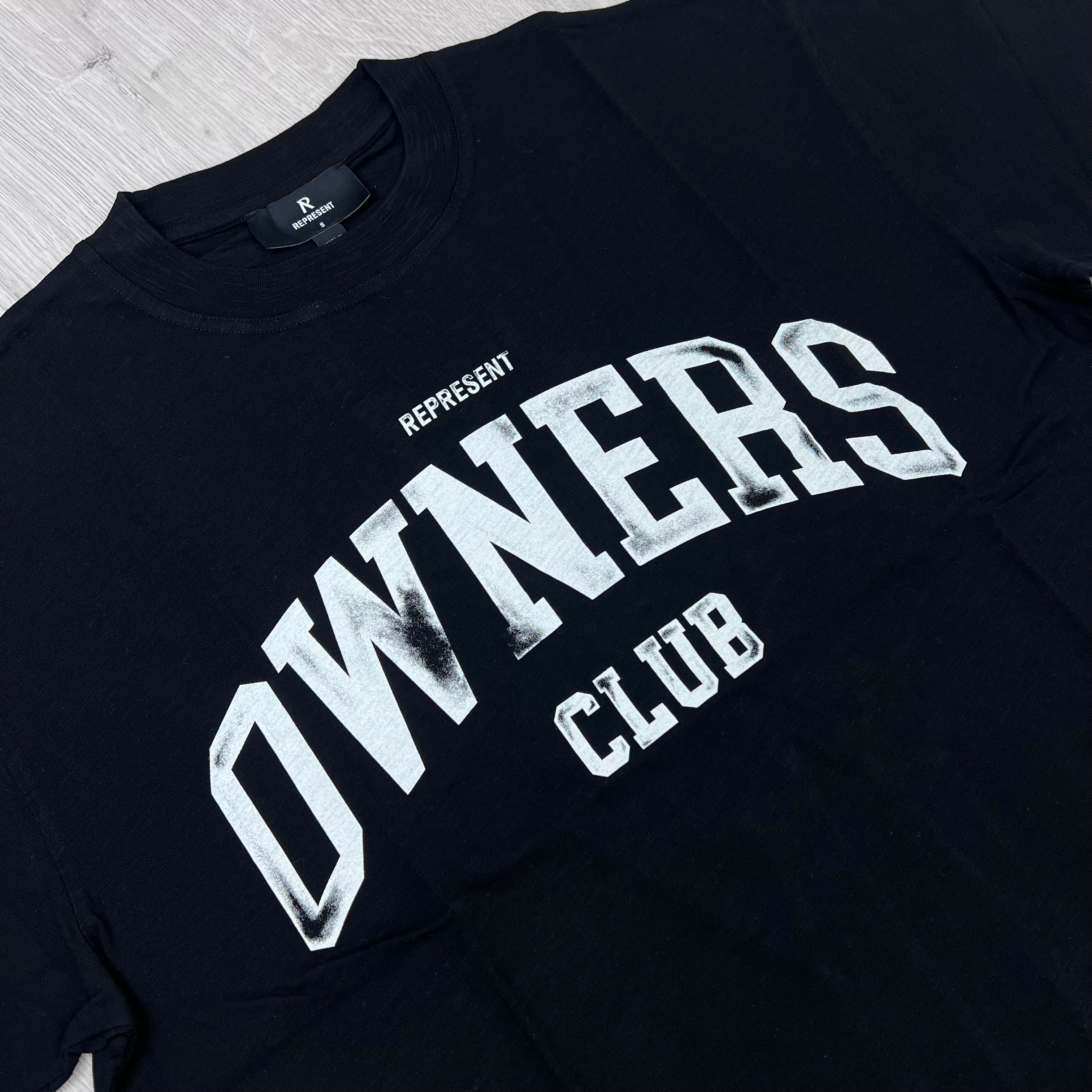 A close up view of the screen printed logo on the Represent Owners Club T-Shirt in Jet Black.