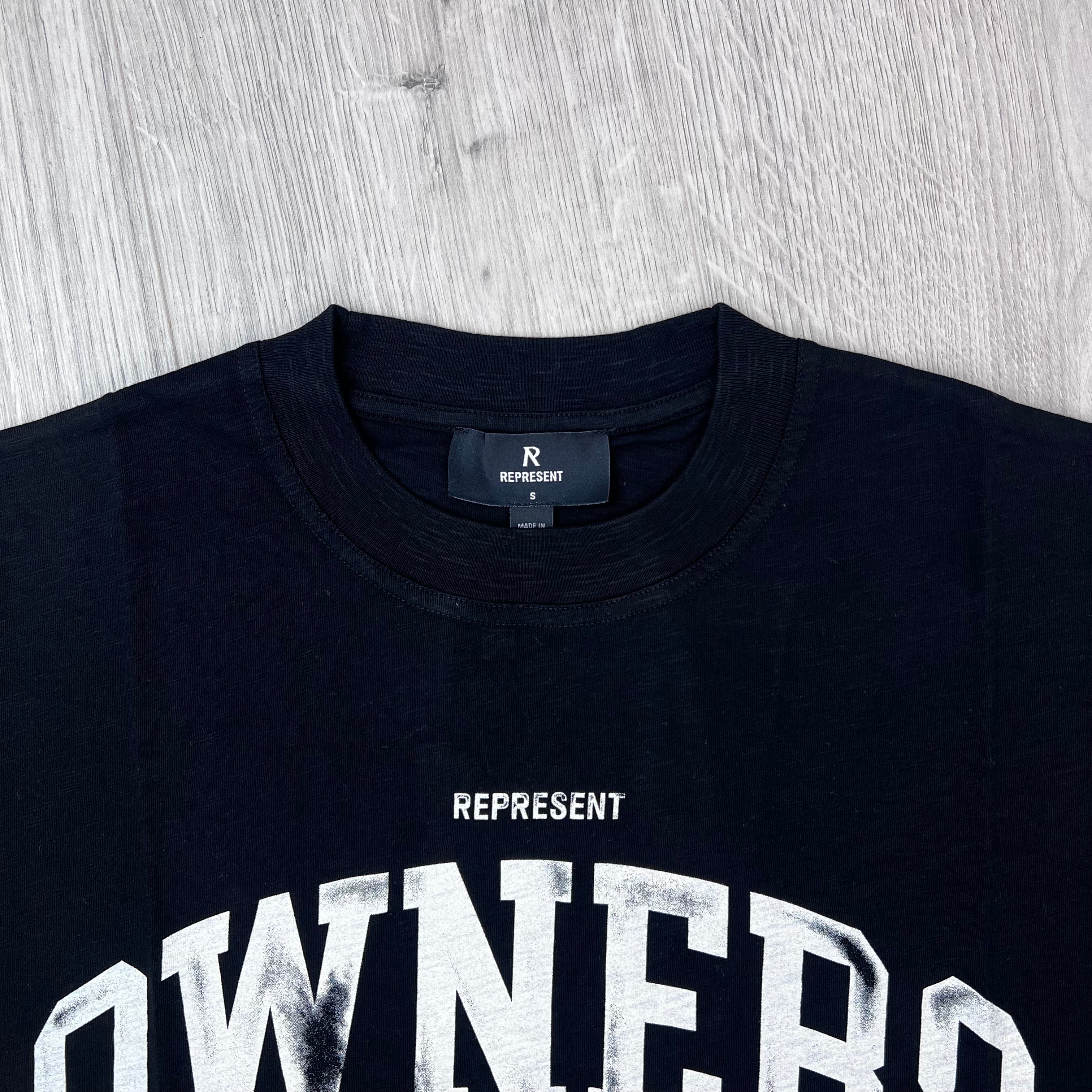A close up view of the crewneck collar and neck label on the Represent Owners Club T-Shirt in Jet Black.